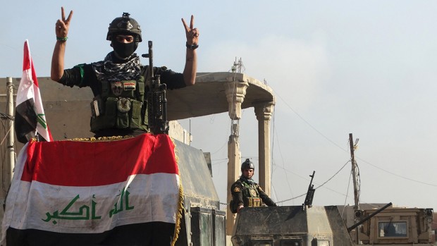 A member of the Iraqi security forces gestures at a government complex in the city of Ramadi, December 28, 2015.