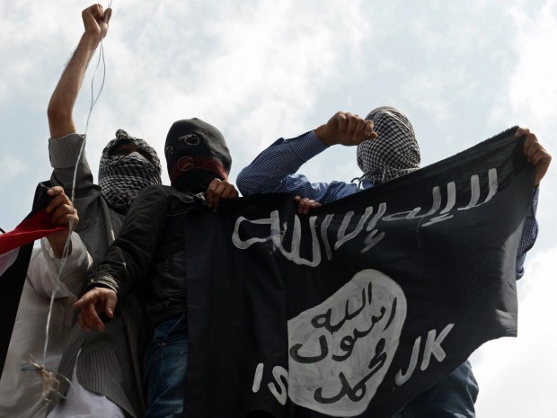 Kashmiri demonstrators hold up a flag of the Islamic State of Iraq and the Levant (ISIL) during a demonstration against Israeli military operations in Gaza