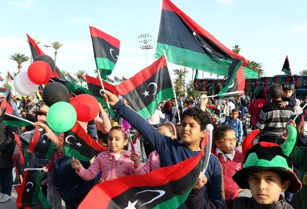 Libyans wave their national flags during a rally to celebrate the country's 64th independence anniversary at the Martyrs square in the capital Tripoli, on December 24, 2015. AFP PHOTO / MAHMUD TURKIA / AFP / MAHMUD TURKIA