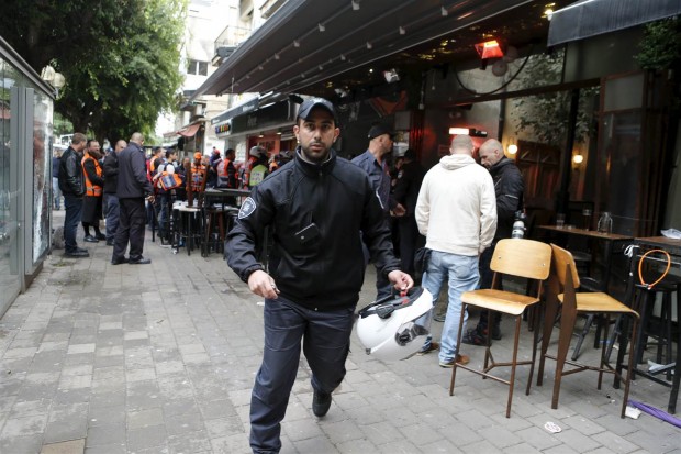 A policeman runs at the scene of a shooting incident in Tel Aviv, Friday. NIR ELIAS / Reuters