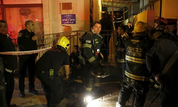 Israeli firefighters at the entrance to the building that houses the offices of human rights group B’Tselem. Photograph: Ronen Zvulun/Reuters