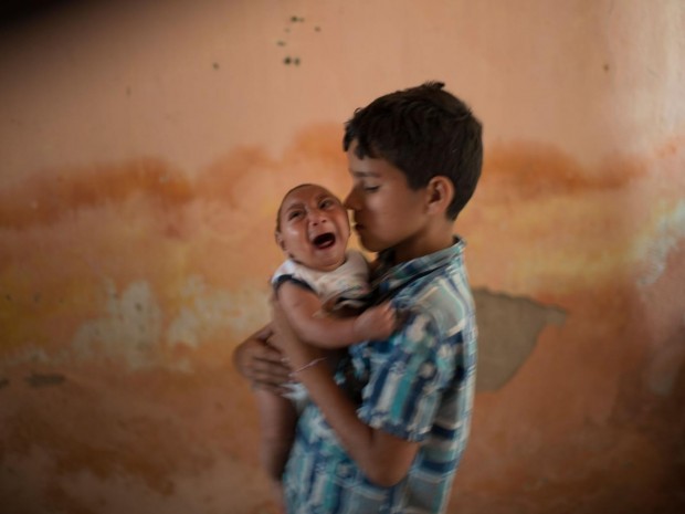 Two-month-old Jose Wesley, born with microcephaly in Brazil, is nursed by his brother AP