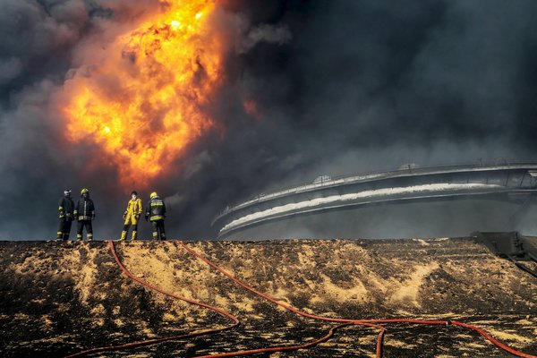 Rescue workers responded to an oil tank fire in Ras Lanuf, Libya, caused by a bombing, one of several in the country this month. Credit Reuters