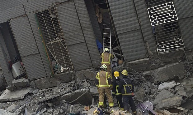 Rescue personnel work at a damaged building. Photograph: Pichi Chuang/Reuters