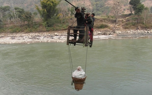 Residents of Dhaing village use a wooden trolley suspended via a cable to cross Trishuli River  Photo: Manish Duwadi / Barcroft India