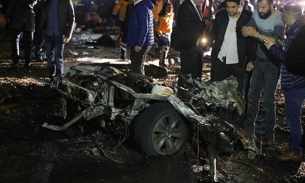  People and security forces gather around the wreckage of a car at the scene of a blast in Ankara. Photograph: Erol Uceem/AFP/Getty Images 