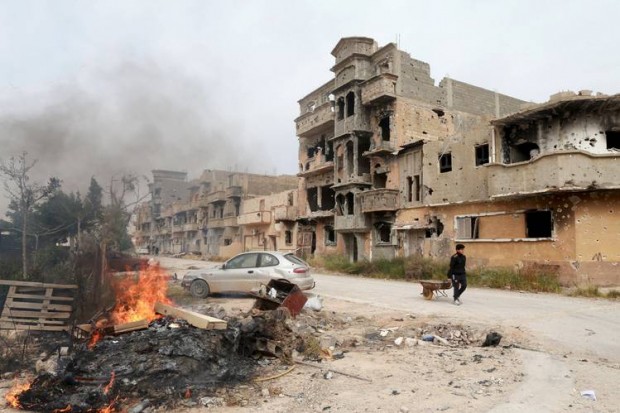 A man walking past destroyed buildings after clashes between military forces loyal to Libya's internationally recognized government and Islamist fighters in Benghazi on Sunday. PHOTO: ESAM OMRAN AL-FETORI/REUTERS