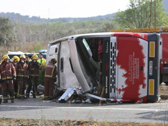 Firemen work at the site of a coach crash that has left at least 14 students dead at the AP-7 motorway in Freginals, in the province of Tarragona, northeastern Spain (EPA)