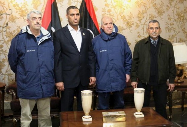 Tripoli-based Libyan Foreign Minister Ali Abu Zakouk (R) stands with Gino Pollicardo (L) and Filippo Calcagno (2nd R), two Italian civilians held hostage near the western Libyan city of Sabratha since last July, after they were freed, at Mitiga International Airport in Tripoli, Libya March 6, 2016. REUTERS/Hani Amara