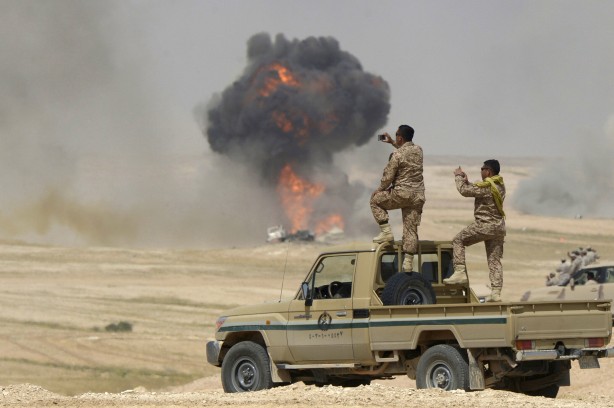 Soldiers take pictures as flame and smoke are seen following air bombardments during the Northern Thunder exercises, in Hafr Al-Batin, near Saudi Arabia’s border with Iraq, March 10, 2016. REUTERS/Abedullah al-Desori