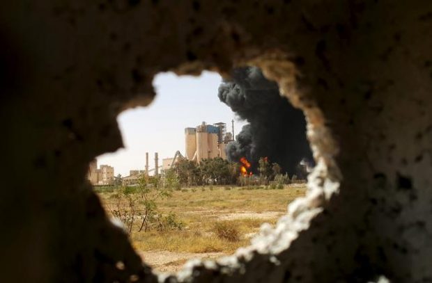 A fire is seen next to the Libyan cement factory during clashes between military forces loyal to Libya's eastern government, who are backed by the locals, and the Shura Council of Libyan Revolutionaries, an alliance of former anti-Gaddafi rebels, who have joined forces with the Islamist group Ansar al-Sharia in Benghazi, Libya April 14, 2016. REUTERS/Stringer