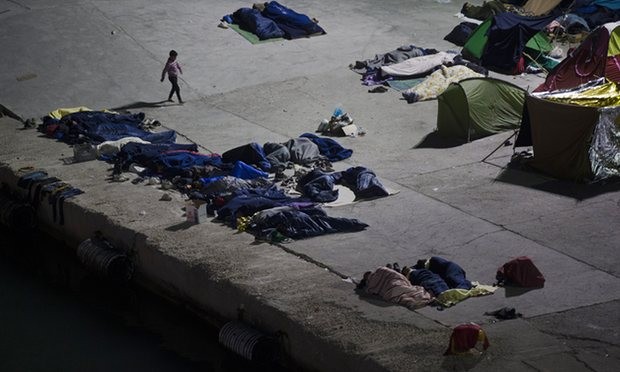 People sleep at the port on Chios island, Greece. Photograph: Petros Giannakouris/AP