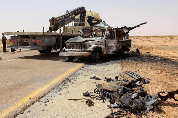 Carnage: A truck removes the remains of a burnt-out vehicle following a car bomb attack on a security post in the Saddada area