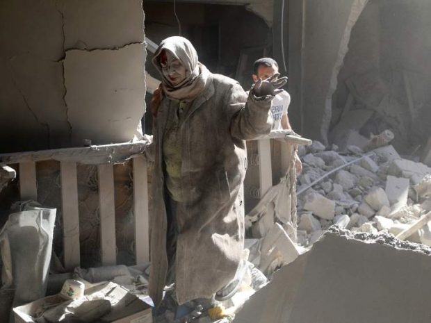 A woman emerges from the rubble of a building after the attack