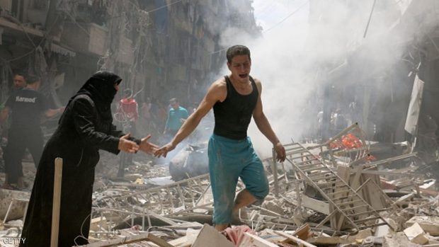 People walk amid the rubble of destroyed buildings following a reported air strike on the rebel-held neighbourhood of al-Kalasa in the northern Syrian city of Aleppo, on April 28, 2016. The death toll from an upsurge of fighting in Syria's second city Aleppo rose despite a plea by the UN envoy for the warring sides to respect a February ceasefire. / AFP / AMEER ALHALBI