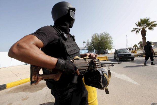 A member of the force assigned to protect Libya's unity government stands at the entrance to where the government has their offices, in Tripoli, Libya.