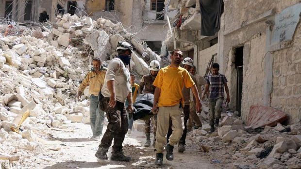 Syrian Civil Defence workers evacuate a body following a regime air strike. / AFP / THAER MOHAMMED