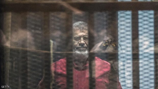 Egypt's ousted Islamist president Mohamed Morsi, wearing a red uniform, stands behind the bars during his trial in Cairo at the police academy in Cairo on April 23, 2016. KHALED DESOUKI/AFP/Getty Images