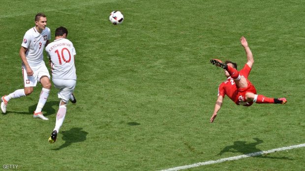 Switzerland's midfielder Xherdan Shaqiri (R) shoots to score his team's equaliser during the Euro 2016 round of sixteen football match Switzerland vs Poland, on June 25, 2016 at the Geoffroy Guichard stadium in Saint-Etienne. / AFP / JEAN-PHILIPPE KSIAZEK        (Photo credit should read JEAN-PHILIPPE KSIAZEK/AFP/Getty Images)