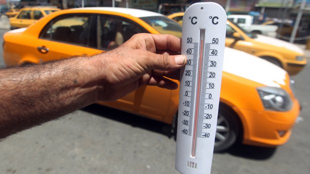 An Iraqi man shows a thermometer reading more than fifty degrees Celsius on July 30, 2015 in the capital Baghdad. AFP PHOTO / AHMAD AL-RUBAYE (Photo credit should read AHMAD AL-RUBAYE/AFP/Getty Images)