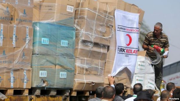 Palestinians unload Turkish aid shipments upon arrival in the Gaza Strip at Kerem Shalom crossing between Israel and southern Gaza Strip, July 4, 2016.