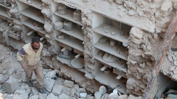 A civil defence member looks for survivors amid rubble of damaged houses after an airstrike on rebel held Old Aleppo, Syria July 16, 2016. REUTERS/Abdalrhman Ismail