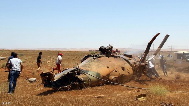 Libyan emergency personnel inspect the wreckage of a military helicopter that crashed during an airshow in the eastern city of Benghazi on July 4, 2013, killing two crew members and wounding a third, an airforce official told AFP. The accident occurred while a military parade was underway at the Benina airbase in Benghazi, Libya's second city and cradle of the 2011 uprising that toppled dictator Moamer Kadhafi. AFP PHOTO/ABDULLAH DOMA        (Photo credit should read ABDULLAH DOMA/AFP/Getty Images)