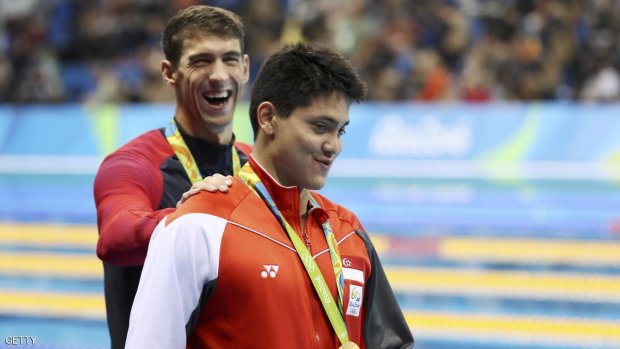 2016 Rio Olympics - Swimming - Victory Ceremony - Men's 100m Butterfly Victory Ceremony - Olympic Aquatics Stadium - Rio de Janeiro, Brazil - 12/08/2016. Joseph Schooling (SIN) of Singapore is congratulated by Michael Phelps (USA) of USA as they leave the podium.   REUTERS/Stefan Wermuth FOR EDITORIAL USE ONLY. NOT FOR SALE FOR MARKETING OR ADVERTISING CAMPAIGNS.