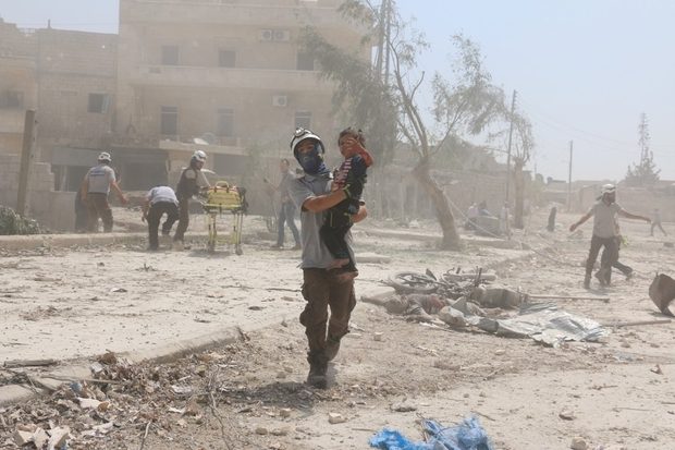 A Syrian rescue woker carries a child in the Maadi district of eastern Aleppo after government aircrafts reportedly dropped explosive-packed barrel bombs (AFP)