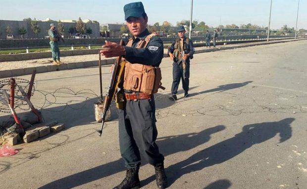 Afghan policemen stand guard at the site of a blast in Kabul, Afghanistan