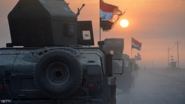 Pro-government forces drive in military vehicles in Iraq's eastern Salaheddin province, south of Hawijah, on October 10, 2016, as they clear the area in preparation for the push to retake the northern Iraqi city of Mosul, the last Islamic State (IS) group held city in Iraq.  / AFP / Mahmoud al-Samarrai