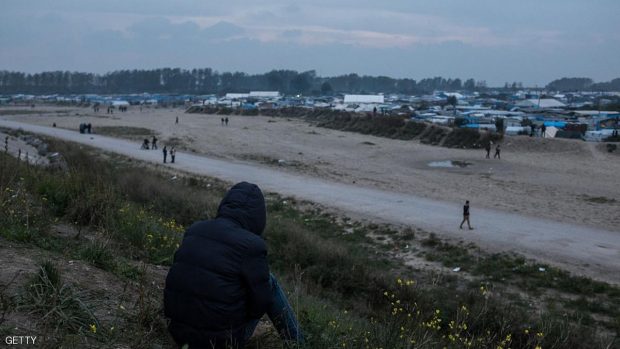 A Migrant sits in the Calais Jungle in Calais, France  on an embankment an looks in the direction if the camp on 23 October 2016. The refugee camp on the coast to the English Channel is to be cleared on monday, according to the French government. The approximately 8,000 refugees are distributed to various reception centers in France. (Photo by Markus Heine/NurPhoto via Getty Images)