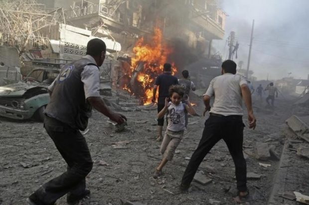 A boy runs as he rushes away from a site hit by what activists said were airstrikes by forces loyal to Syria's President Bashar al-Assad in the Douma neighborhood of Damascus, Syria August 24, 2015. REUTERS/Bassam Khabieh