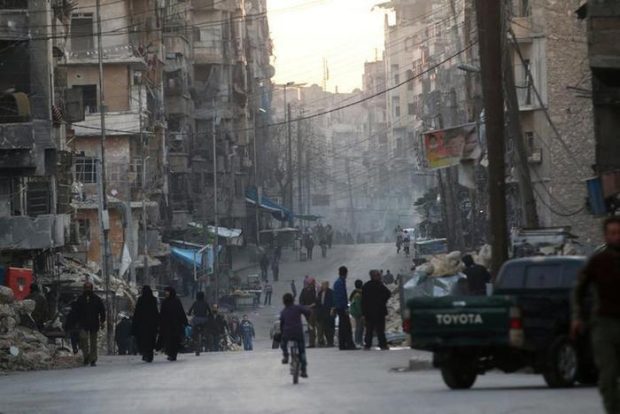 People walk along a street near damaged buildings in Tariq al-Bab neighbourhood of Aleppo, Syria November 2, 2016. REUTERS/Abdalrhman Ismail  - RTX2RKHP