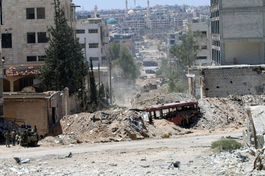 Forces loyal to Syria's President Bashar Assad stand near barricades after they advanced on the southern side of the Castello road in Aleppo, Syria, Thursday. | SANA / HANDOUT VIA REUTERS