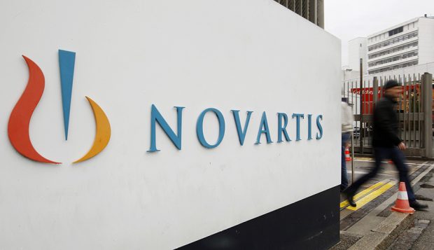 A man walks past the logo of Swiss drugmaker Novartis AG in front of a plant in Basel. REUTERS/Arnd Wiegmann/Files